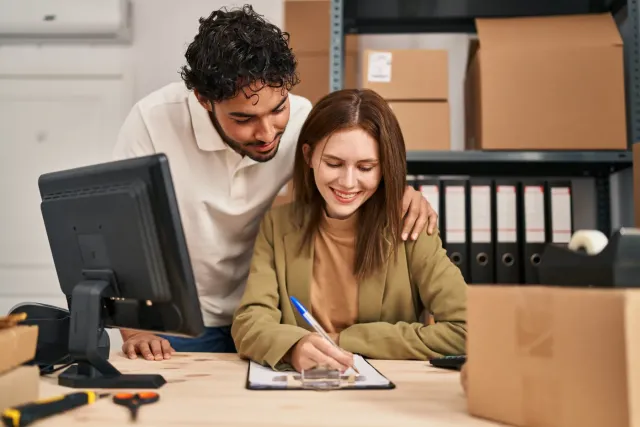 Two people reviewing work together at a computer
